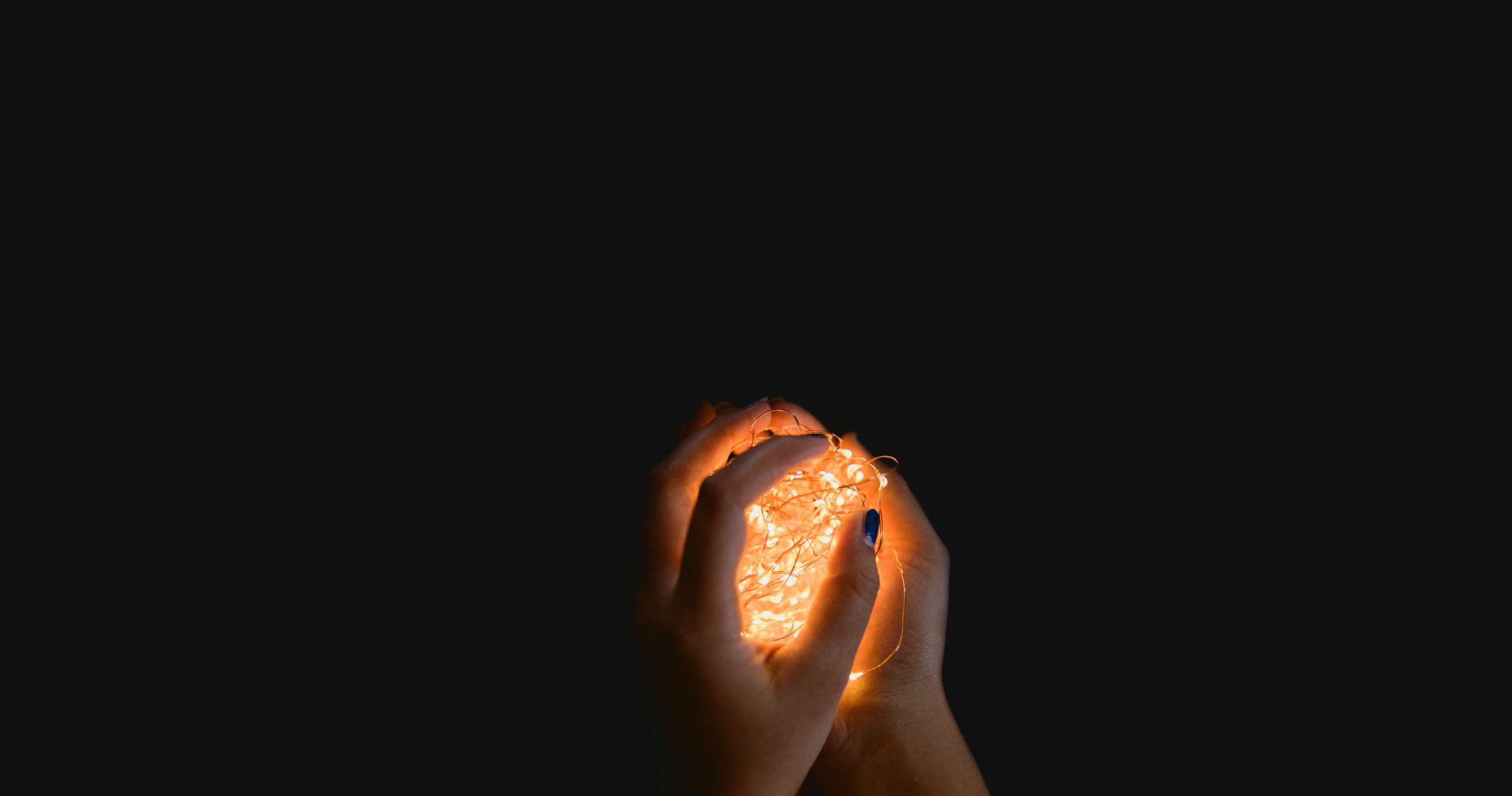 person clutching a ball of lights