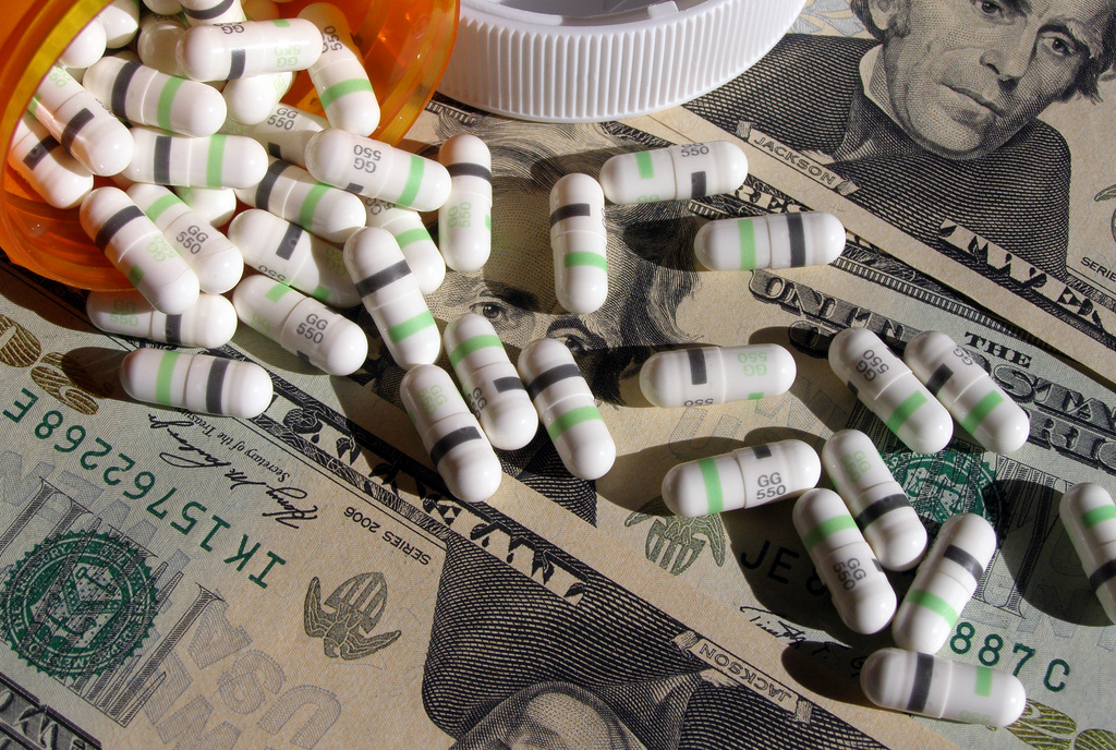 Image of pills over twenty dollar bills
